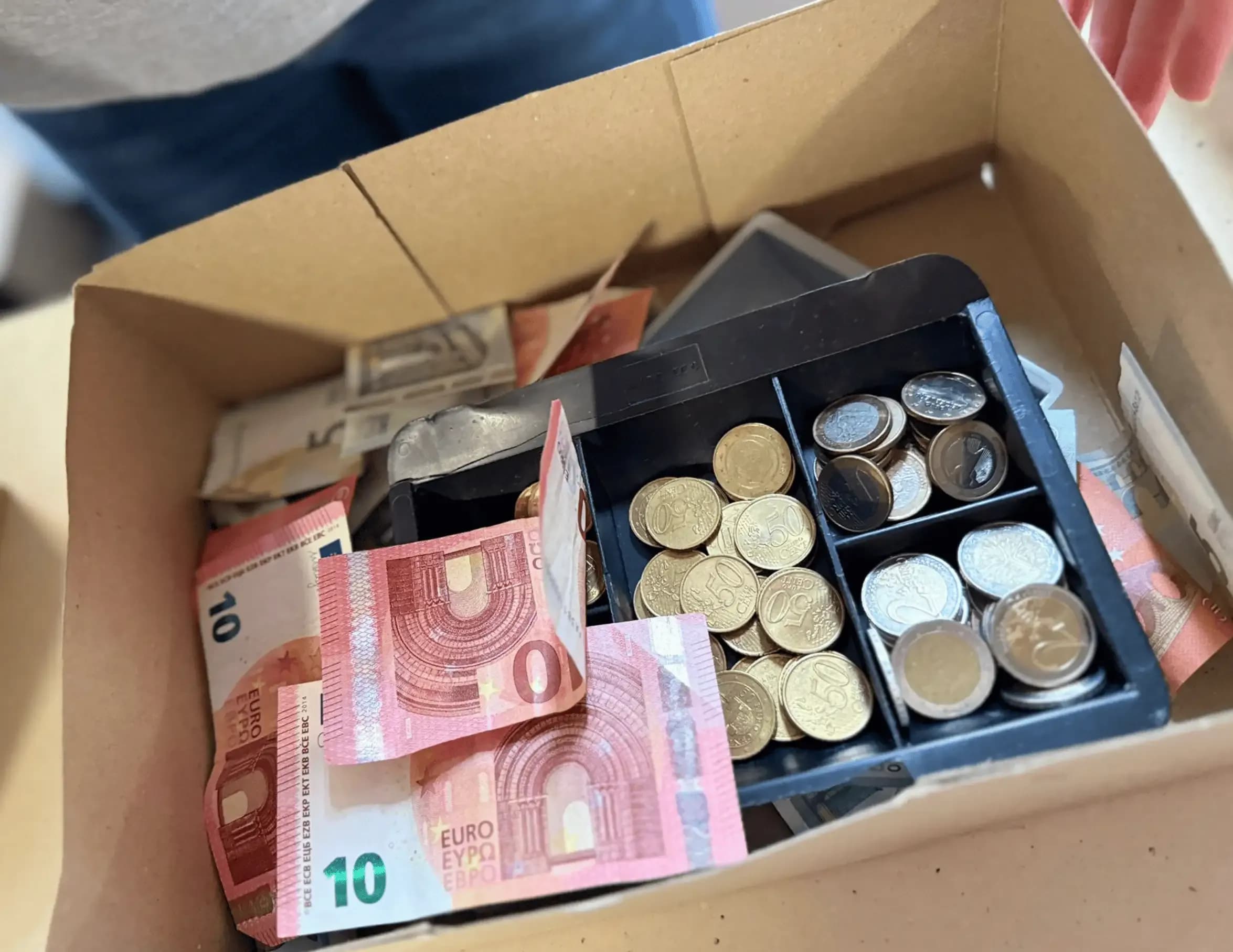 Kassenbox mit Münzen und Geldscheinen